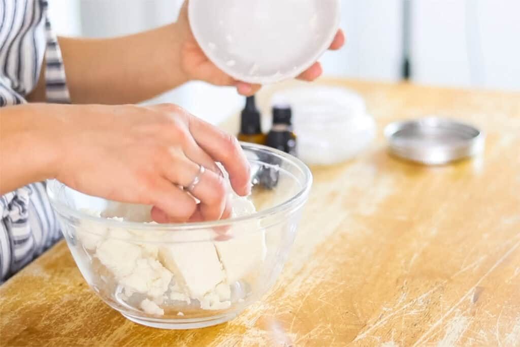 Adding the chunks of shea butter to a glass bowl.