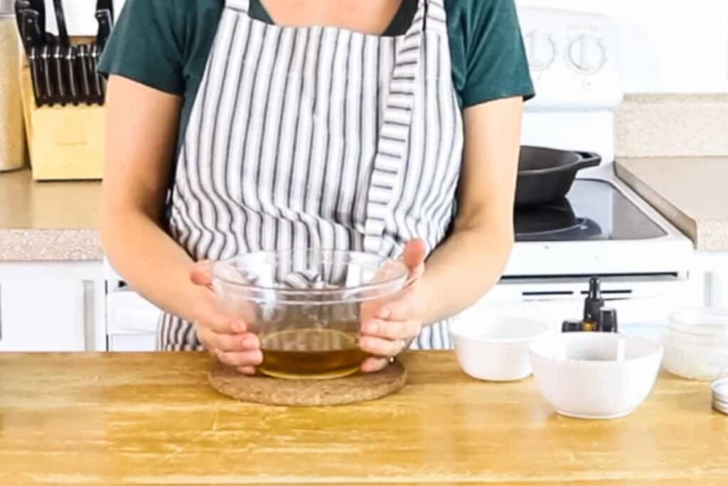Setting the melted oils in the glass bowl down on a cork hot pad to cool.