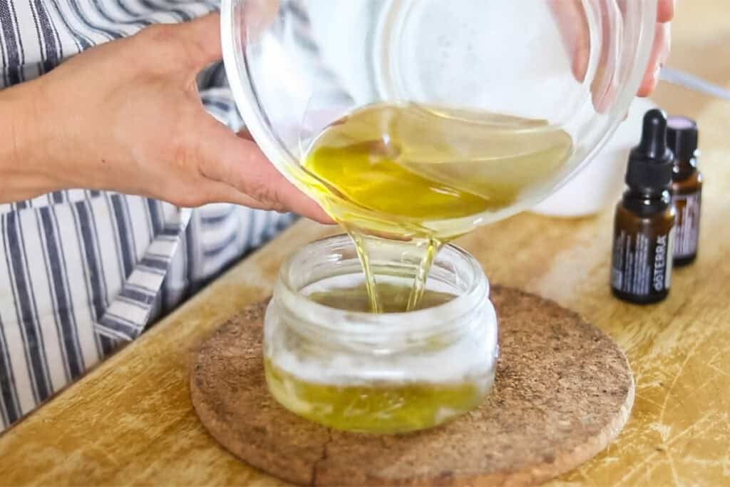 Pouring the melted moisturizer into a glass container for storage.
