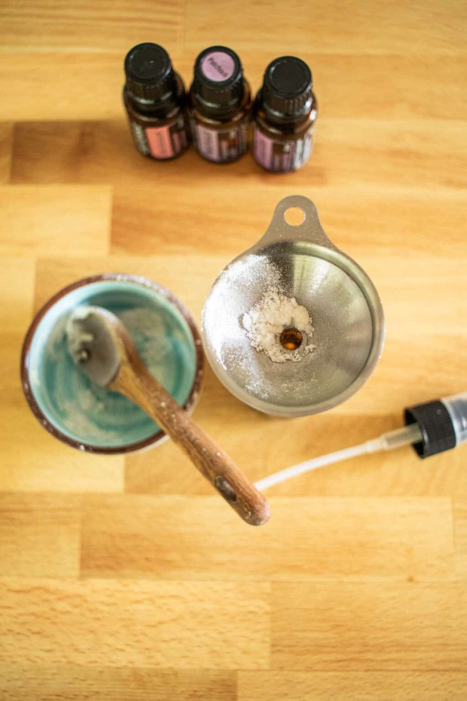 An empty bowl with a spoon in it and a funnel with baking soda in it.