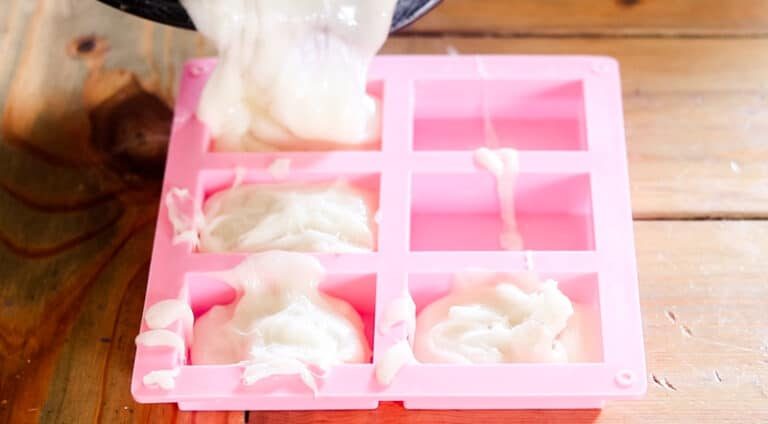 Pouring melted soap into the purple rectangle soap molds.