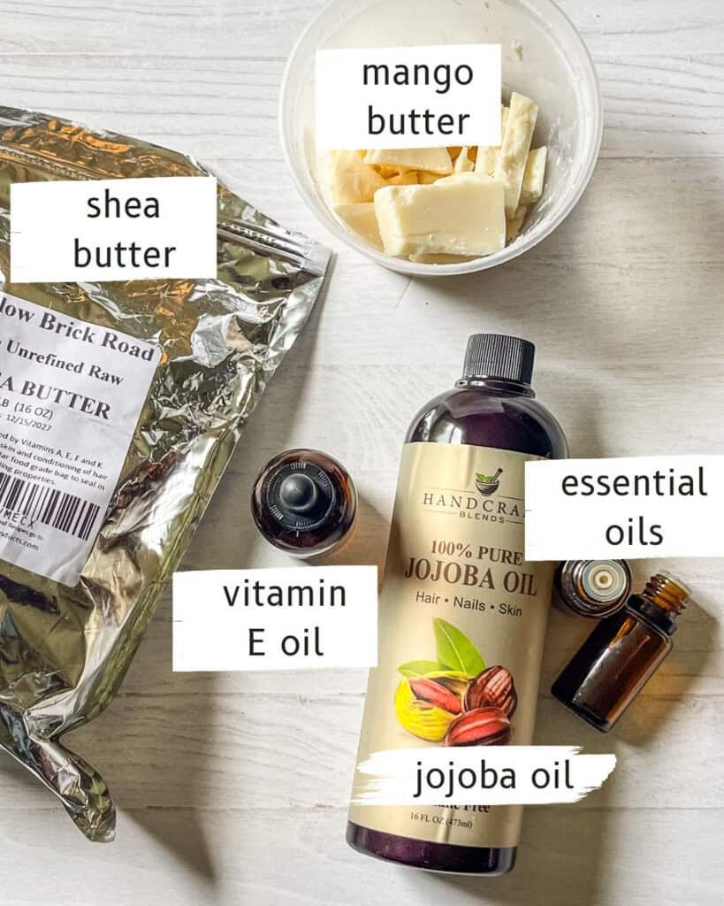 Labeled ingredients for homemade hand cream on a white, wooden table.