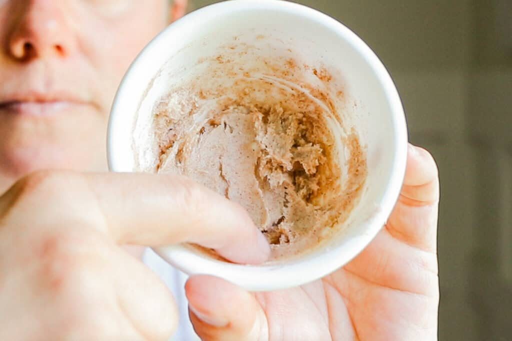 Scooping a bit of lip plumper onto the finger for quick application.
