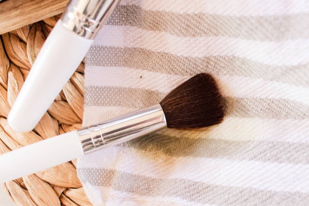 Drying a makeup brush on a striped towel.