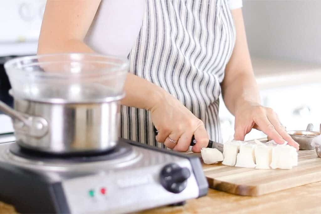 the studio cutting mango butter into chunks about 1-inch thick.