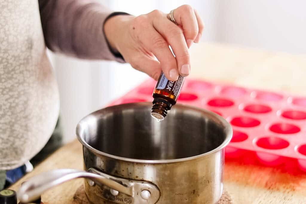 Dropping essential oils into the saucepan.