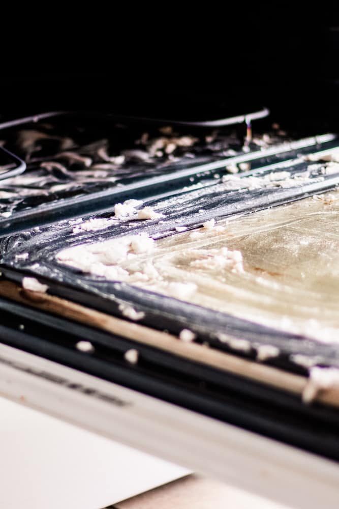 The inside of an oven with a baking soda paste spread on it to clean the grime.