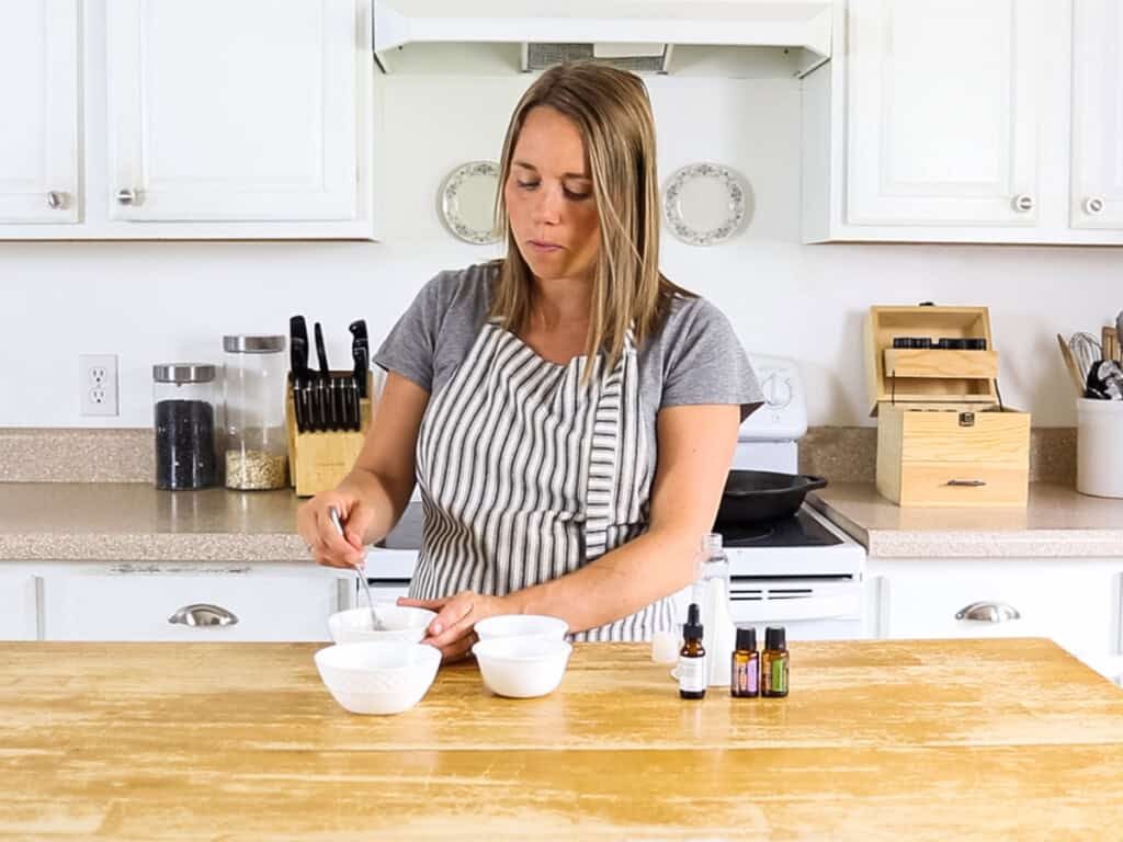 Stirring rosemary shampoo in a white bowl.