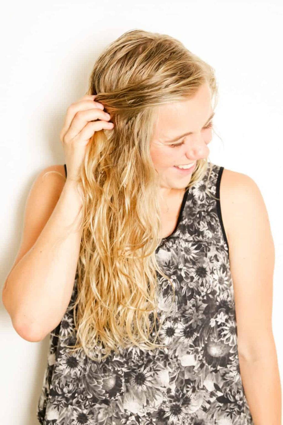 Scrunching hair after spraying with sea salt spray.