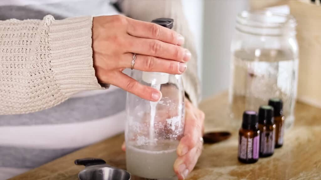 Tightening the lid for the shampoo dispenser before shaking it well to mix the ingredients.
