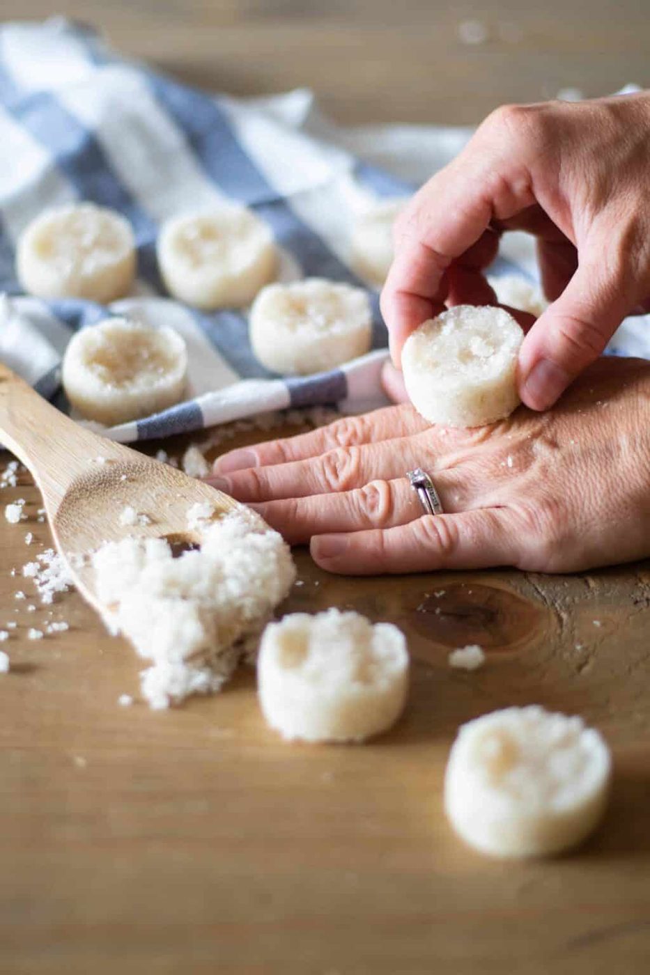 Homemade healthy sugar scrub bars on blue and white towel and wooden table.