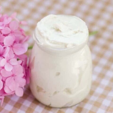 Homemade tallow body butter in a small glass container.