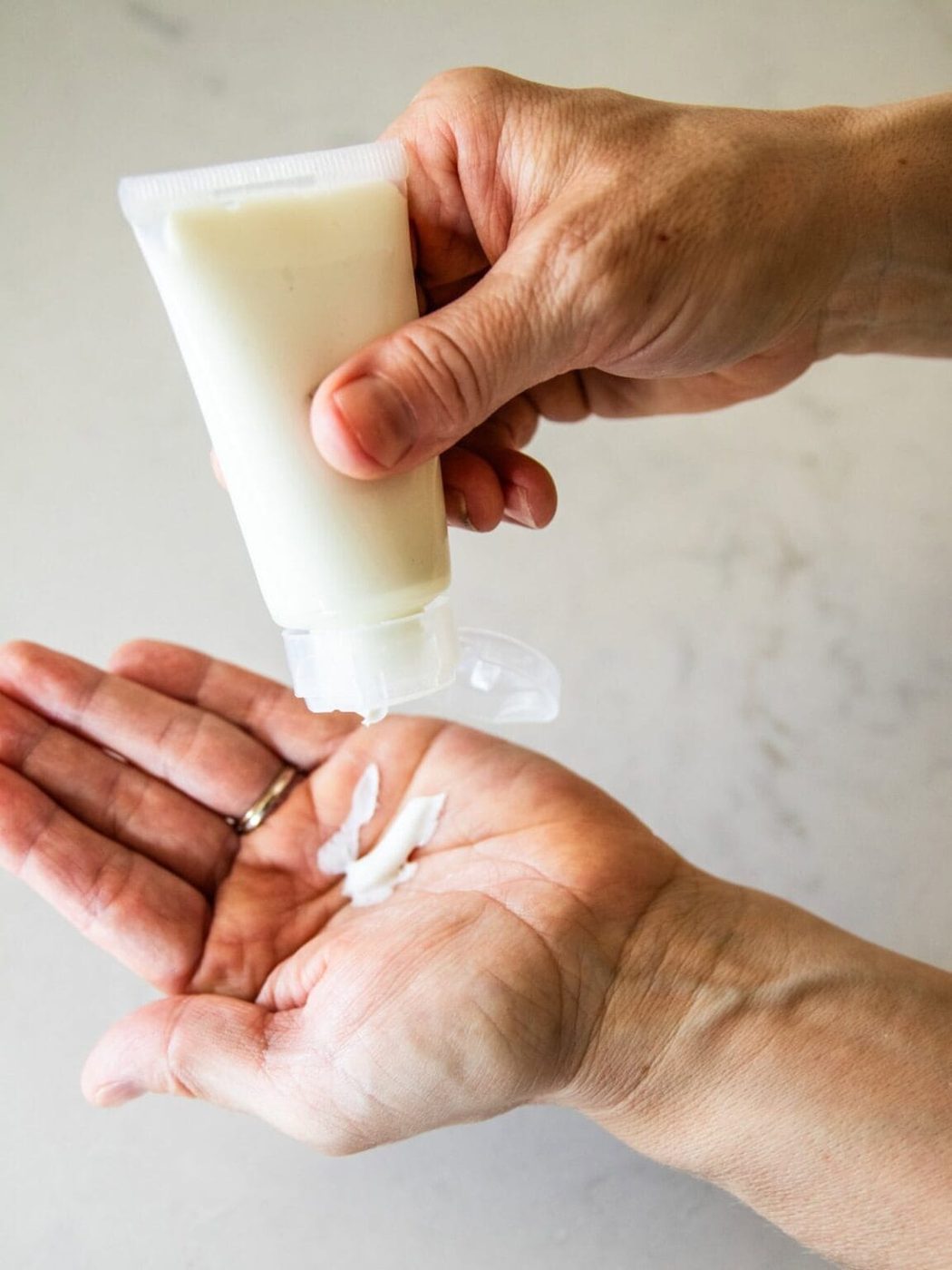 Squeezing a bit of homemade tallow lotion into the palm of the hand.