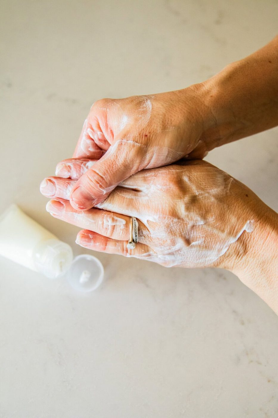 Rubbing homemade tallow lotion into the hands.