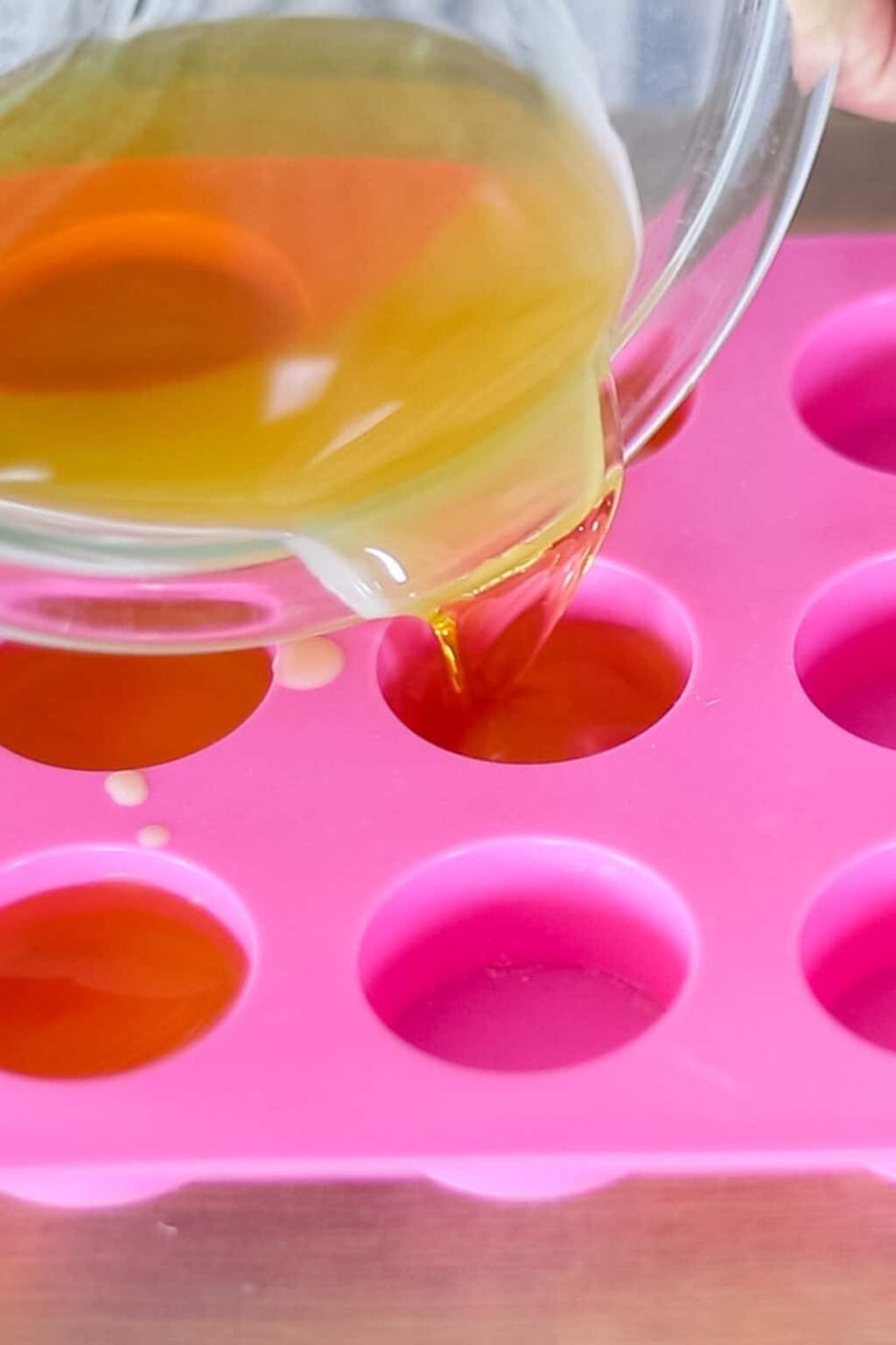 Pouring melted wax mixture into silicone molds.