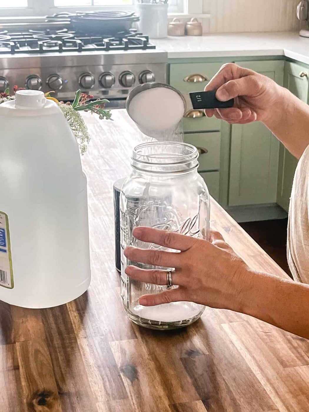 Pouring salt into a large glass jar.