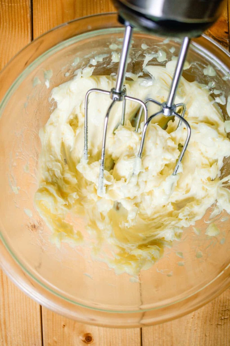Body butter being whipped with a hand mixer until stiff peaks form.