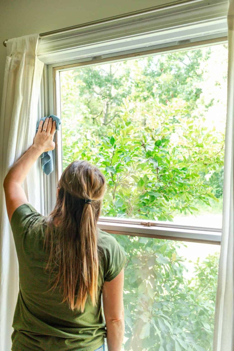 Using a clean and dry microfiber cloth to wipe down the window panes.