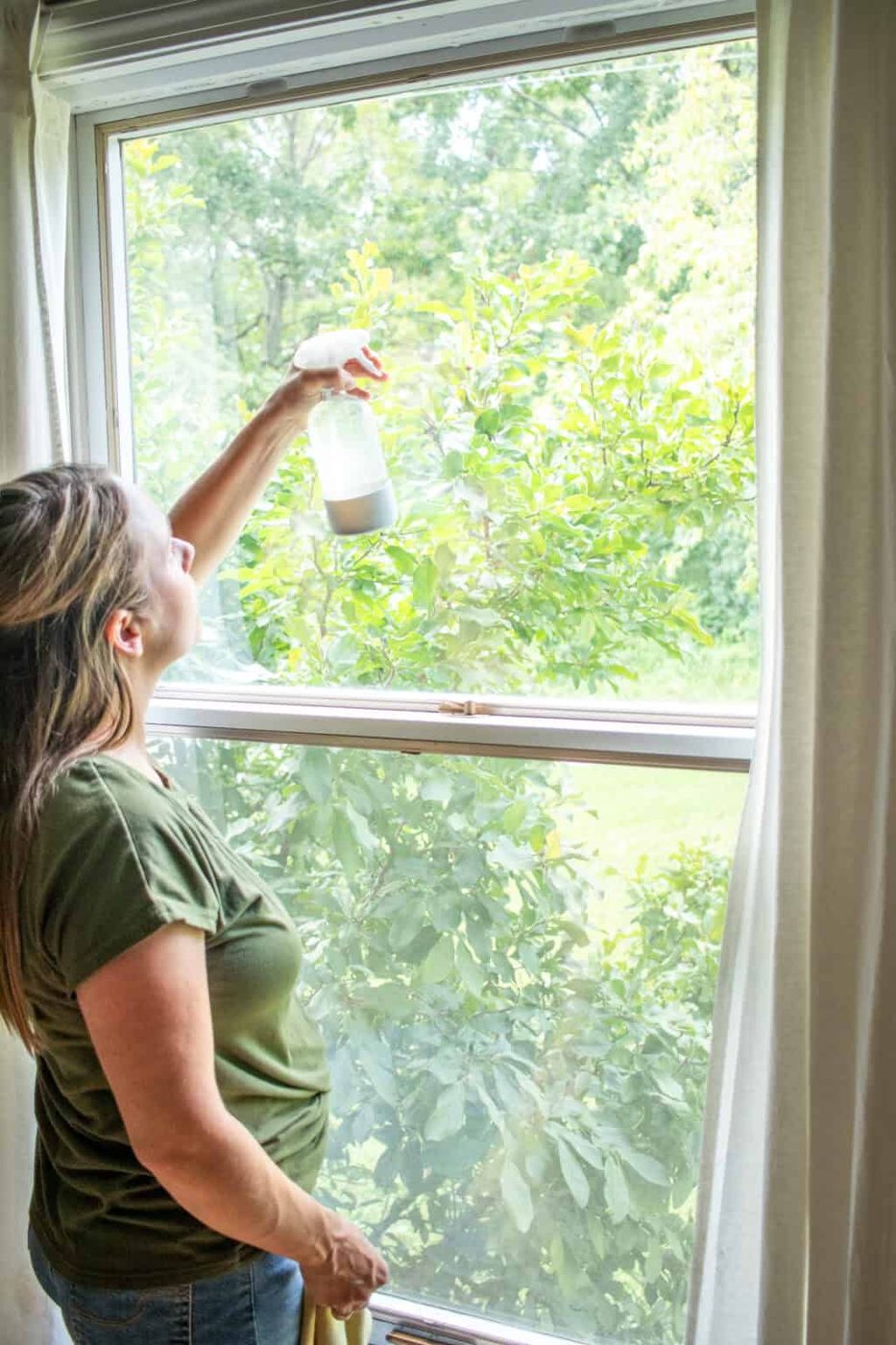 Spraying the window, from the top down with our homemade cleaning solution.