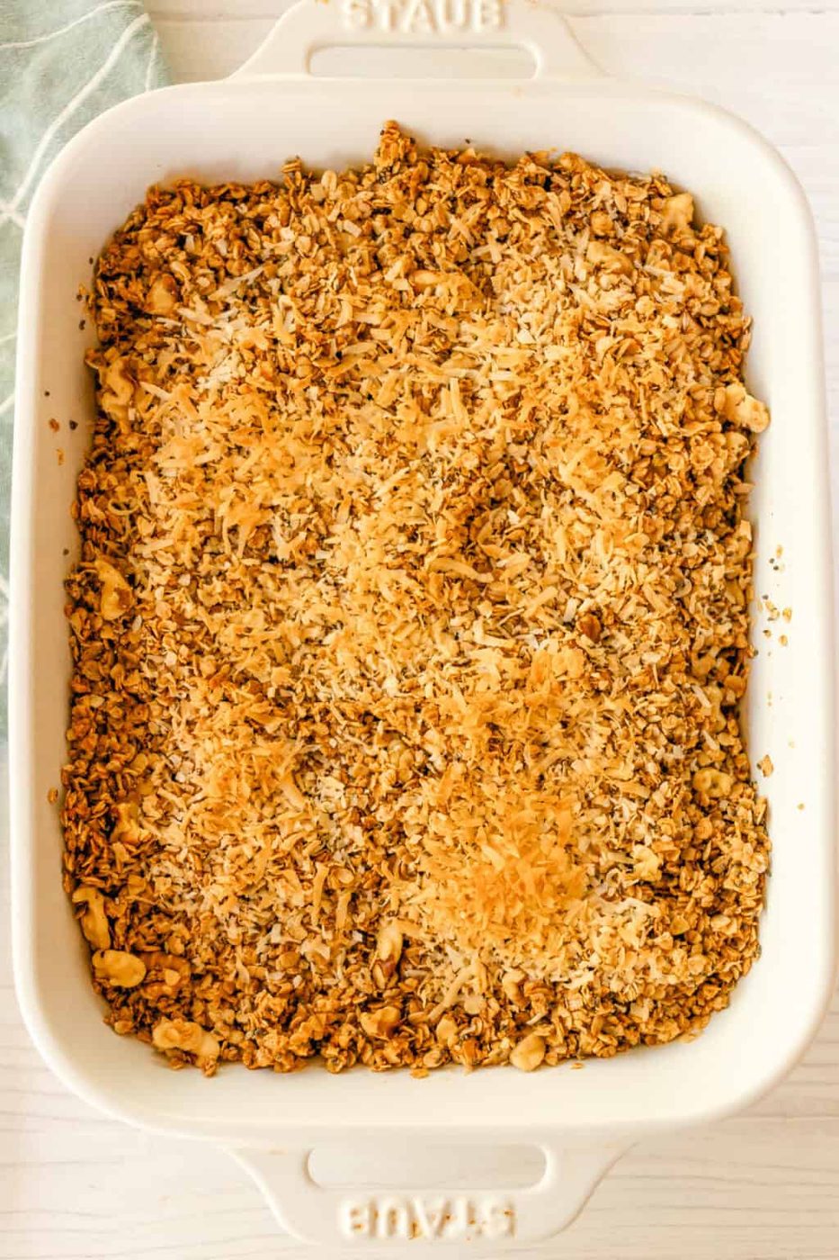 Granola with toasted coconut in a baking dish.