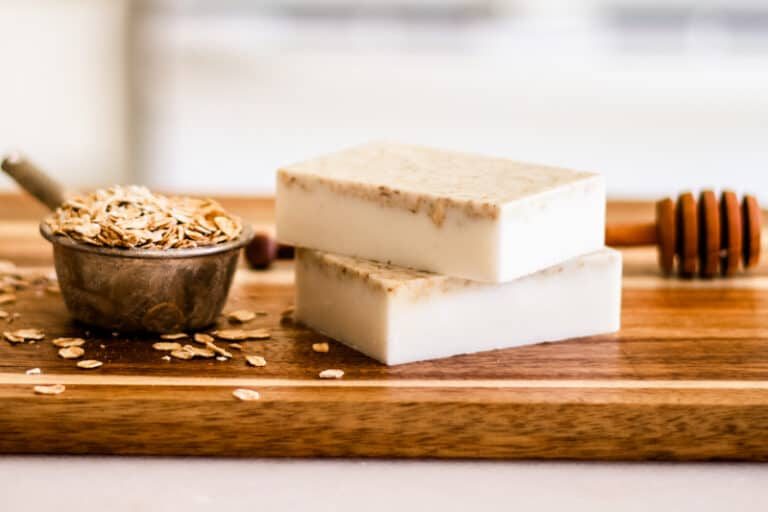 Honey oatmeal soap recipe ingredients ready to be mixed together with two finished bars stacked together.