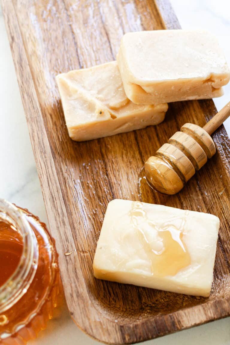 Several homemade honey soap bars with honey drizzled across the top.