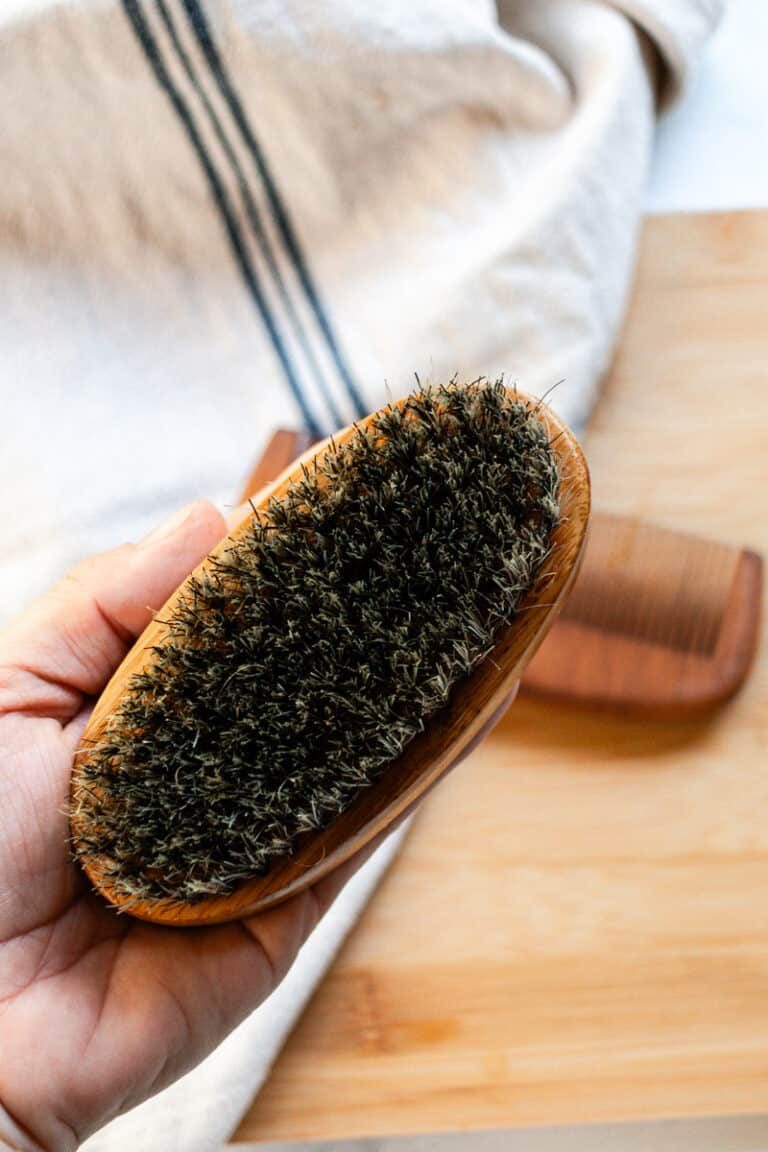 Holding up a viking beard brush after it has been cleaned.