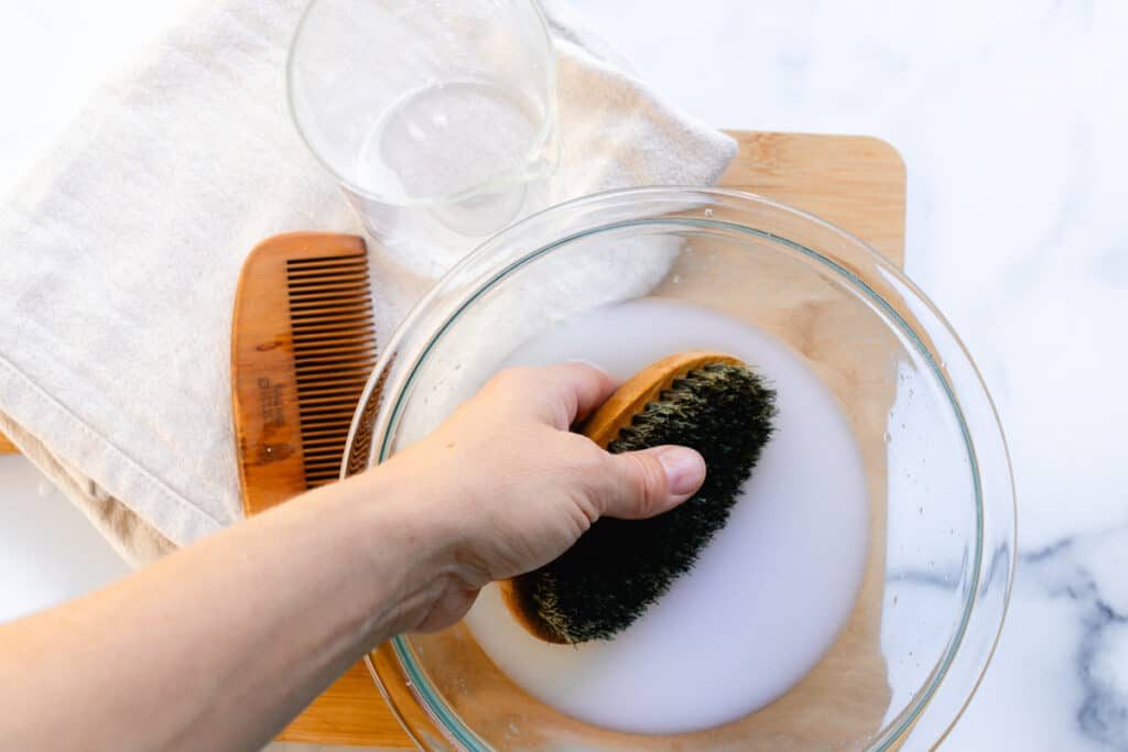 Washing the beard brush with soapy water.