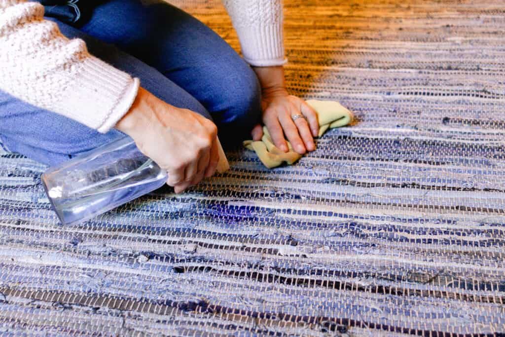 Using plain water to clean off the detergent from the braided rug.