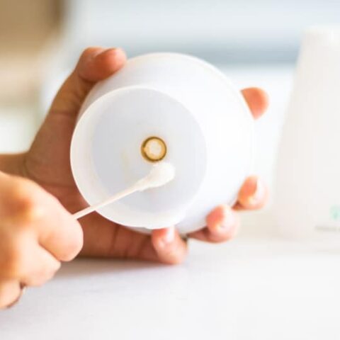 Cleaning a diffuser with a q-tip.