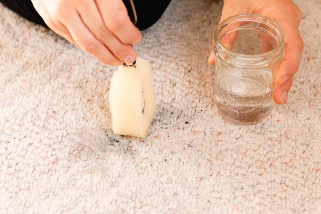 Cleaning soot out of a carpet.