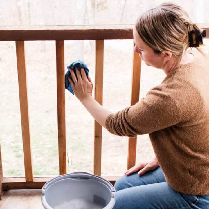 Cleaning a porch screen with warm soapy water and a microfiber cloth.