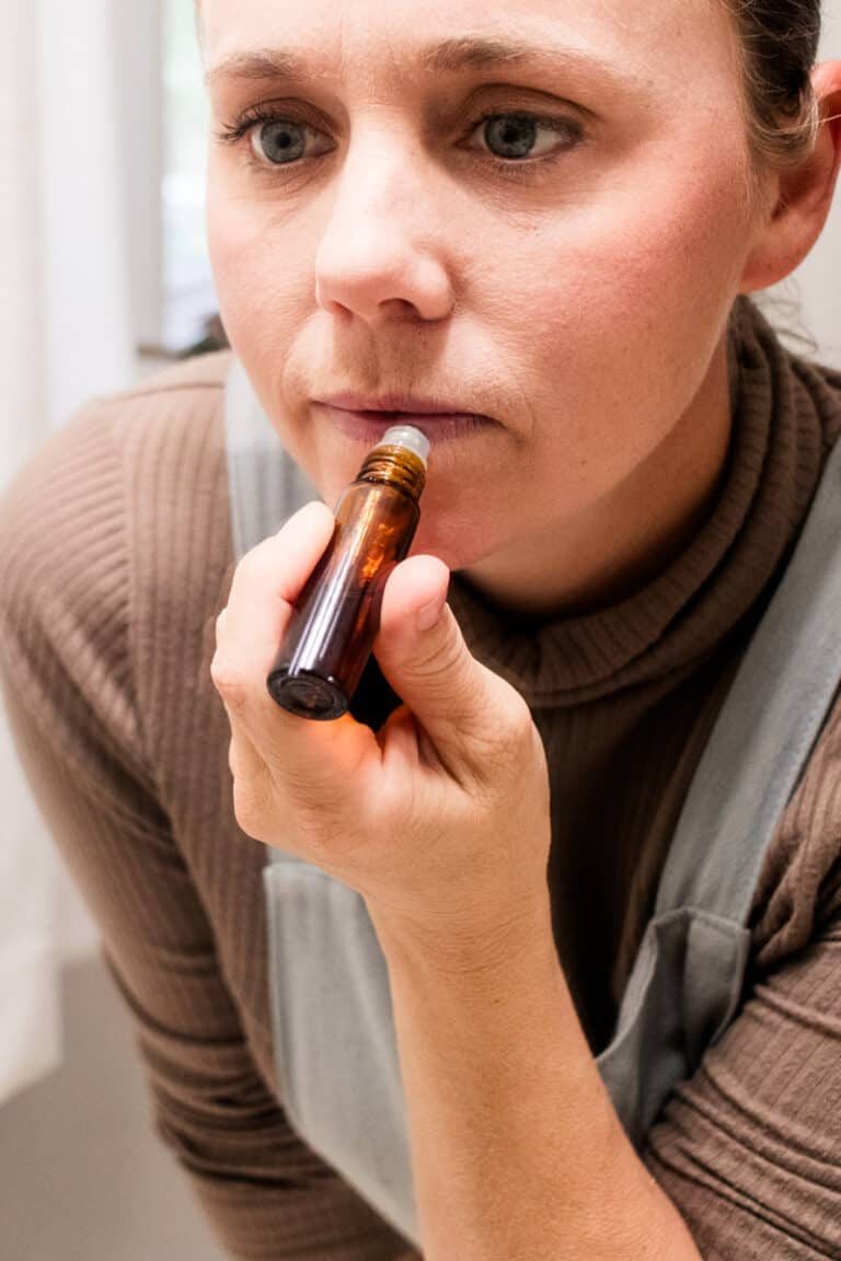 Using the roller ball top to apply the lip oil to our dry lips.