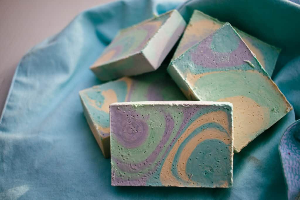 Olive oil soap stacked in a pile on a blue towel.