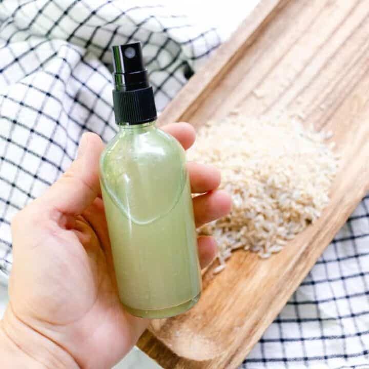 A homemade rice water for hair spray in a clear bottle.