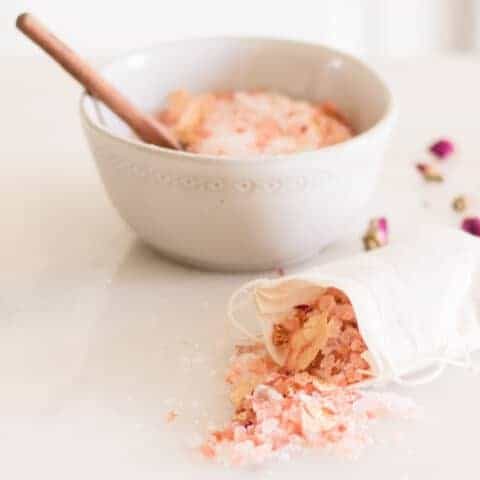 A bag of rose bath salts with a bowl in the background.