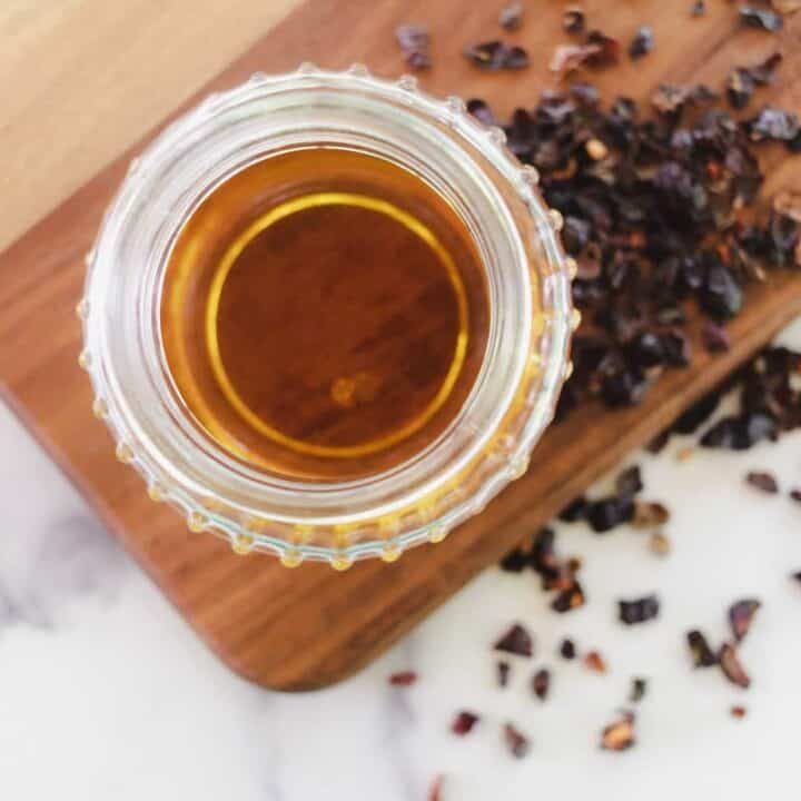Homemade rosehip oil strained and placed in a clear jar.