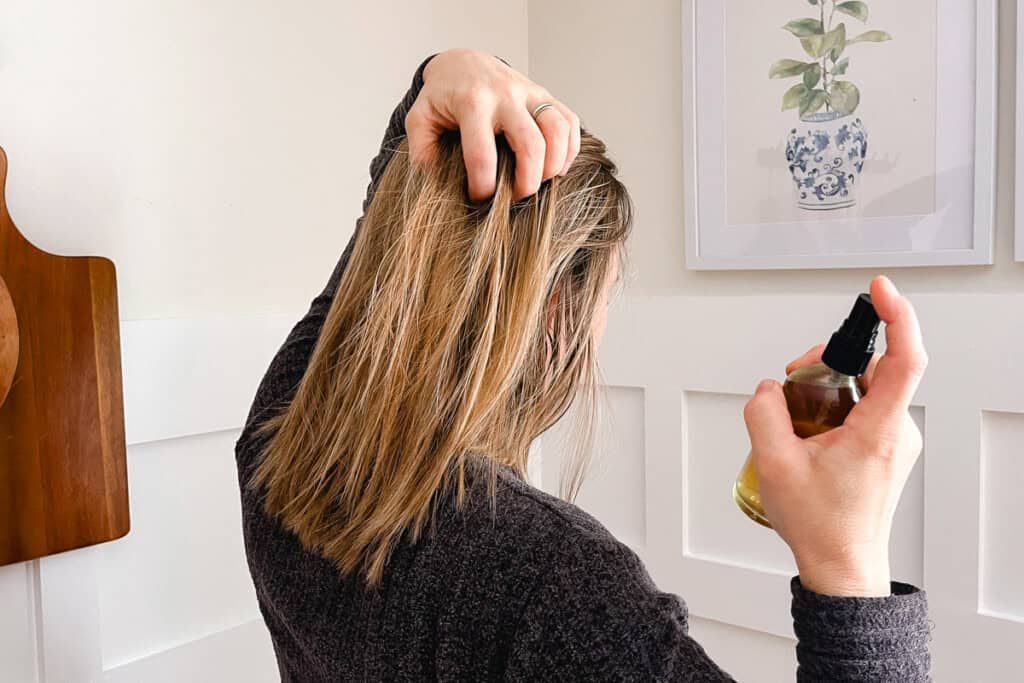 Holding our hair apart as we spray rosemary water onto the strands.