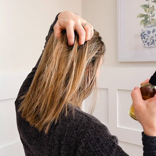 Holding our hair apart as we spray rosemary water onto the strands.