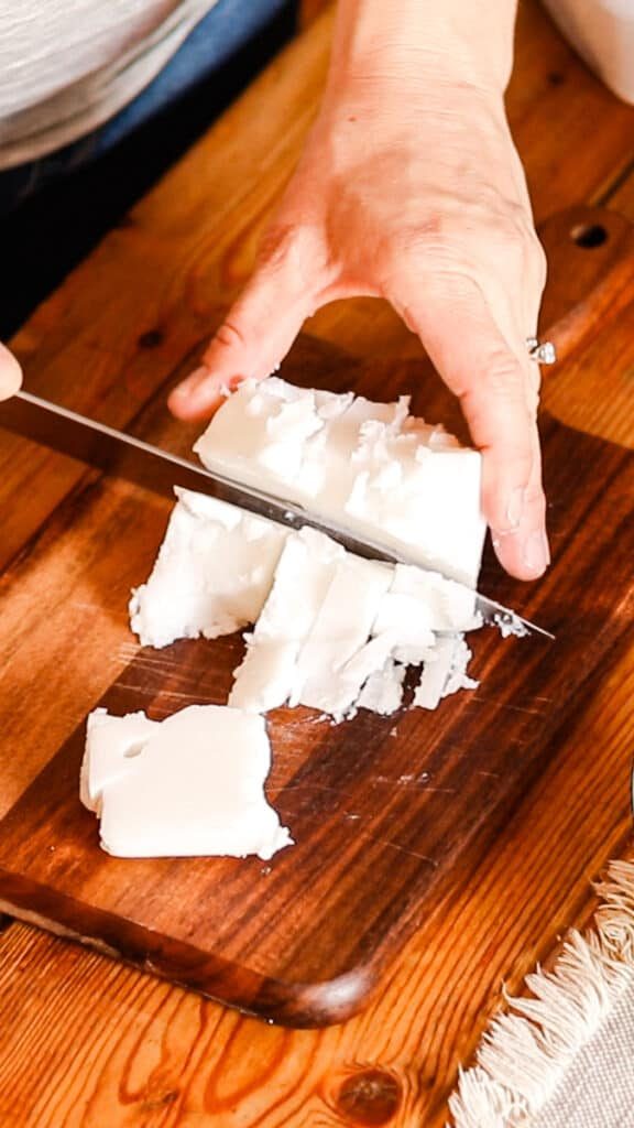 Using a knife to cut the whipped soap base into small pieces.