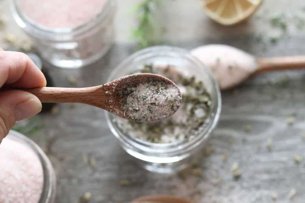 Five homemade seasoning salt blends in jars.