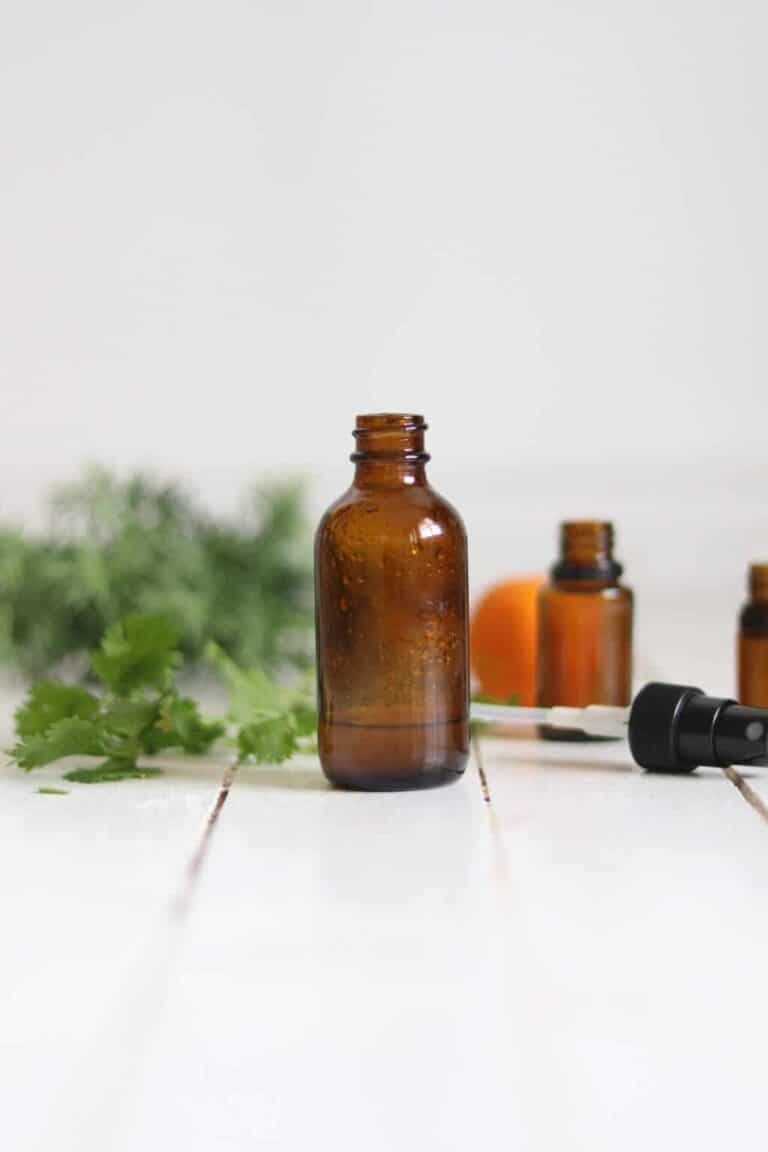 Chlorine detoxing spray in a glass bottle on a white board table.