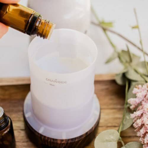Dropping essential oils into a diffuser.