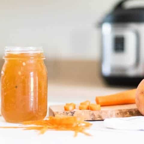 Bone broth and instant pot on white table.
