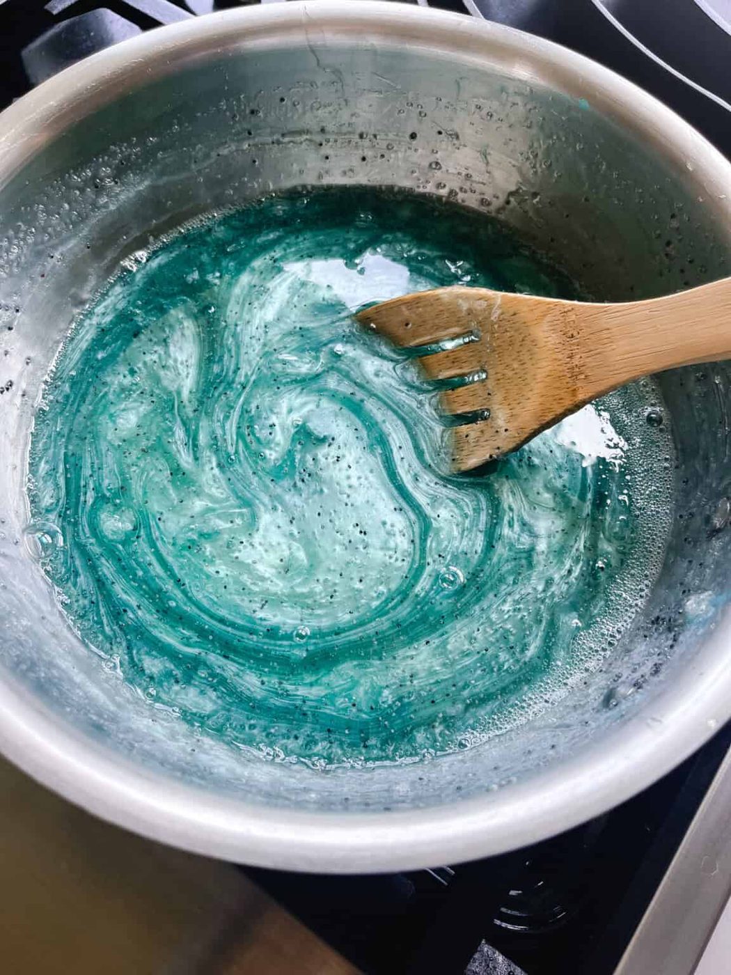 Stirring poppy seeds into melted soap base.