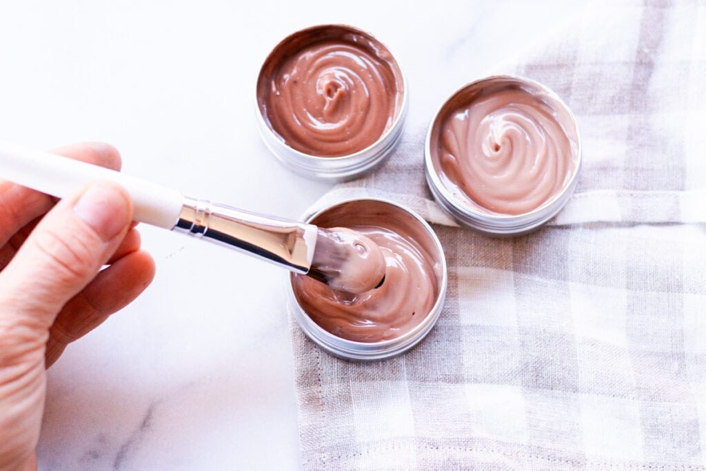 Dipping a foundation brush into the liquid foundation that we made using lotion.