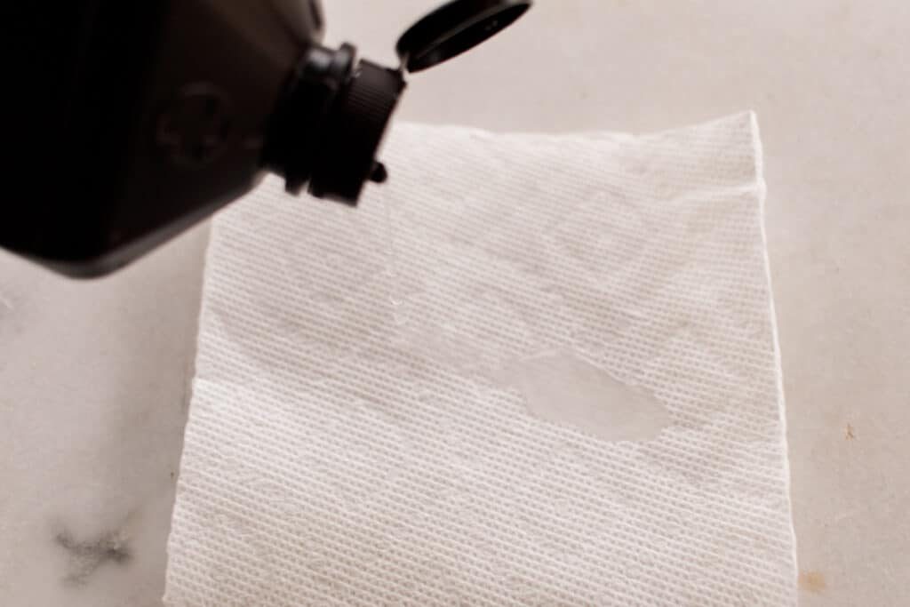 Blotting a white marble stain with hydrogen peroxide.