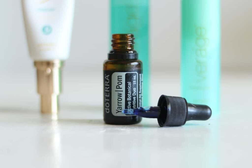 yarrow pom essential oil bottle with Verage skin care products in the background