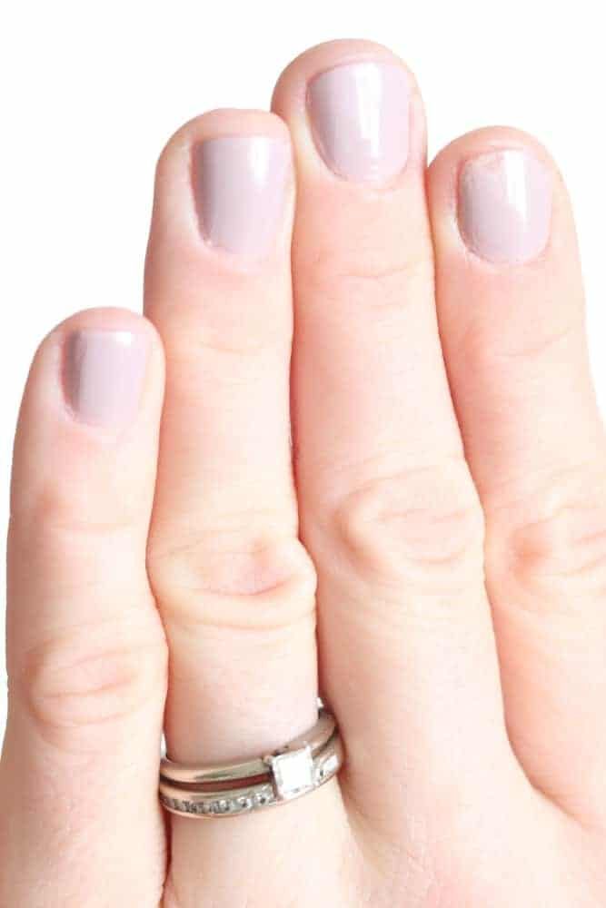 Women's hand with pink nail polish.