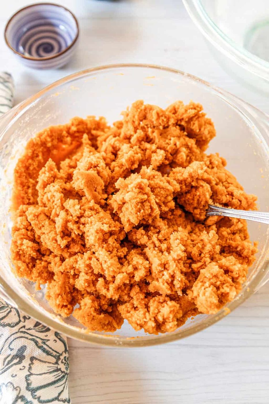 Combining the wet and dry ingredients with a metal spoon.